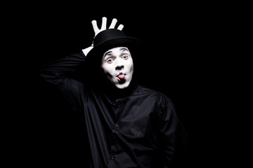 mime sticking tongue out and grimacing isolated on black