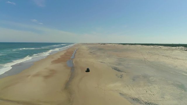 camioneta manejando en la playa, toma a&eacute;rea