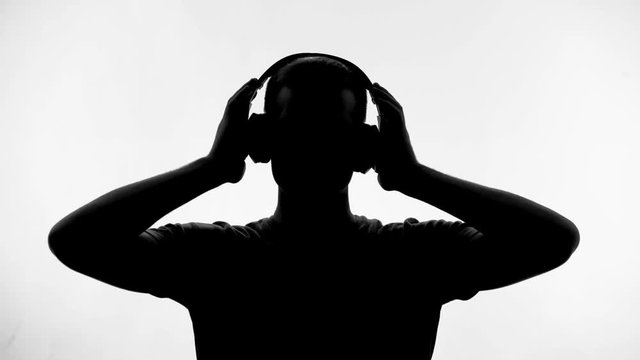 Man putting on headphones and listening to music, enjoying melody, inspiration