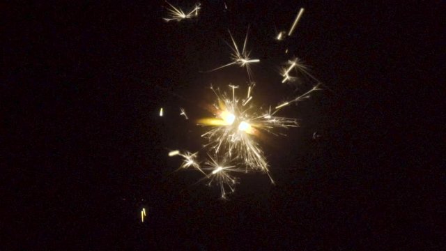 Firework sparkler burning on black background in slow motion