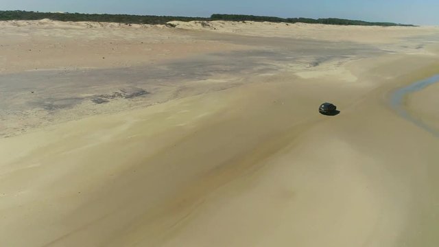 camioneta manejando en la playa, toma a&eacute;rea