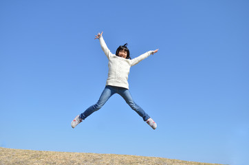 Obraz premium 青空でジャンプする女の子