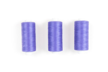 Three purple sewing threads on a white background, sewing accessories and supplies