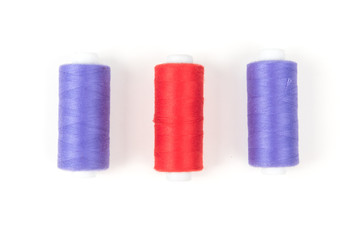 Red and purple sewing threads on a white background. Set of three sewing threads.