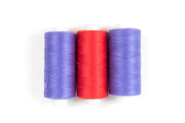Red and purple sewing threads on a white background. Set of three sewing threads.