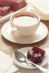 Vertical served table with cherry jam and cup of English tea