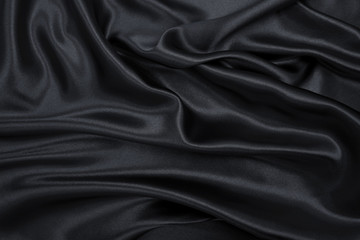 Smooth elegant black silk or satin texture as abstract background. Luxurious background design