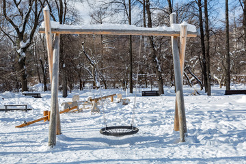 Snow-covered children's playground in public park in winter
