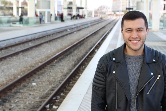 Joyful male smiling at the train station