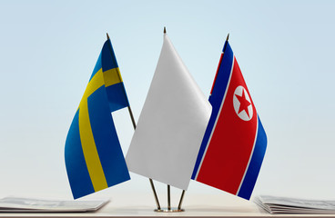 Flags of Sweden and North Korea with a white flag in the middle