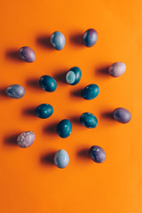 flat lay of colored painted easter eggs on orange