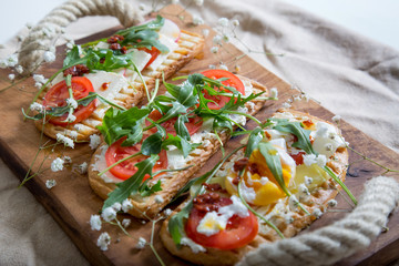 toasts with egg, aragula, tomato and cheese,French toast bread with veggies,Spring healthy toast, healthy breakfast, italian cuisine

