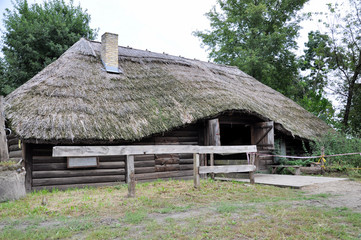 big old wooden house for horses with a thatched roof.