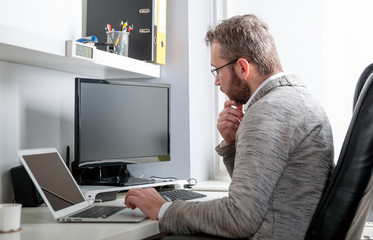 Middle age man working in home office with computer
