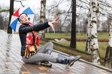 Emotional girl with colorful umbrella on her head in the park