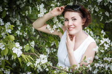 Beautiful girl in Apple tree branches with white flowers