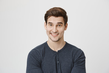 Waist-up portrait of Caucasian handsome attractive young male with dark hair and stubble in casual...