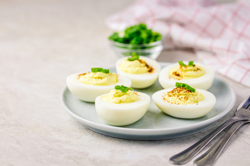 Greek yogurt deviled eggs with paprika and chives on white background. Selective focus ,space for text.