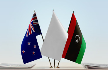 Flags of New Zealand and Libya with a white flag in the middle