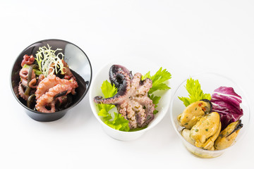 Mini canapes with seafood and vegetables and herbs and in plastic utensils isolated on white background. 