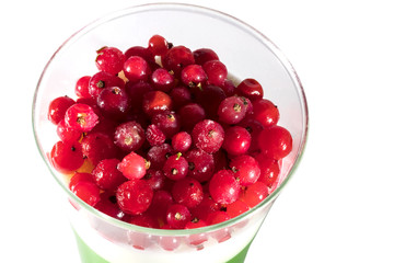 Creamy cream dessert in a plastic cup decorated with berries on a white background. 