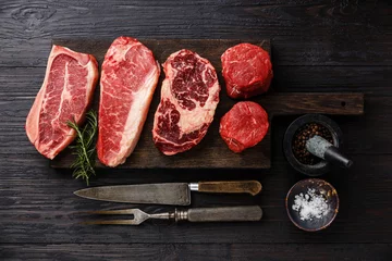 Photo sur Plexiglas Viande Variété de steaks de viande crue Black Angus Prime Lame sur os, contre-filet, faux-filet, filet mignon sur planche de bois