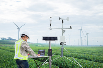 Engineer using tablet computer collect data with meteorological instrument to measure the wind...