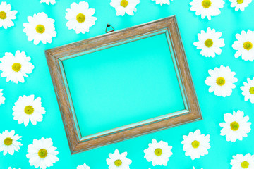 Spring floral frame on  blue cyan background with white daisies texture all around - Fresh flowers composition acuamarine color flat lay top view with copy space - Springtime and summer concept