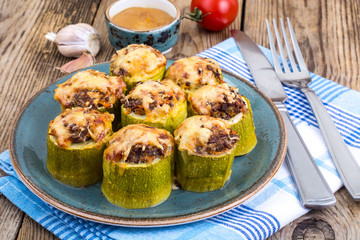 Zucchini stuffed with meat and cheese on blue plate
