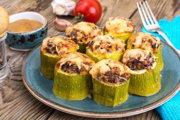 Zucchini stuffed with meat and cheese on blue plate