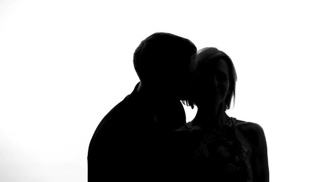 Husband kissing wife on cheek and smiling, newlyweds enjoying each other, flirt