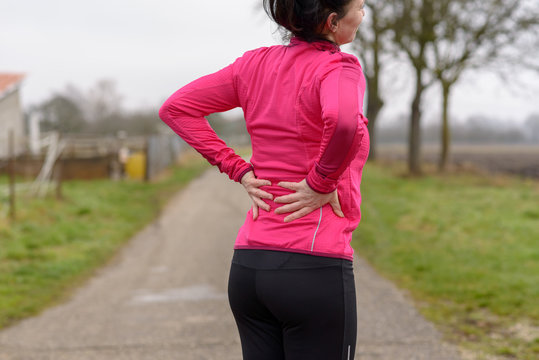 Woman with back or kidney pain clutching her back