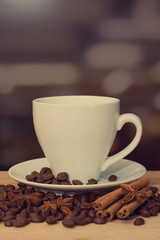 cup of coffee on wooden table with defocus bokeh of coffee shop background. Image with soft focus and blurred background.