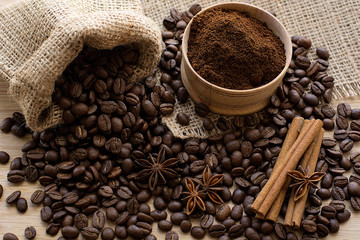 Coffee beans and ground coffee in a wooden spoon.