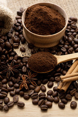 Coffee beans and ground coffee in a wooden spoon.
