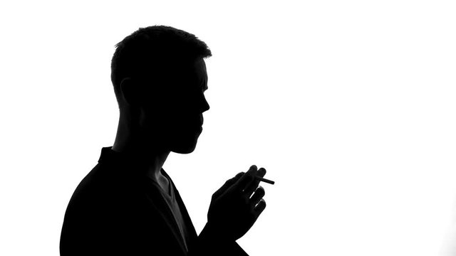 Man shadow lighting cigarette and smoking, unhealthy addiction, dangerous habit