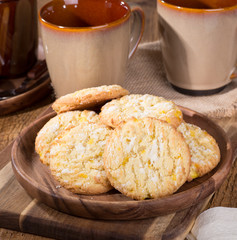 Pile of lemon crackle cookies on a wooden plate