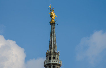 Fototapeta na wymiar the golden statue of the Madonnina, from the spiers of the Duomo dominates Milan