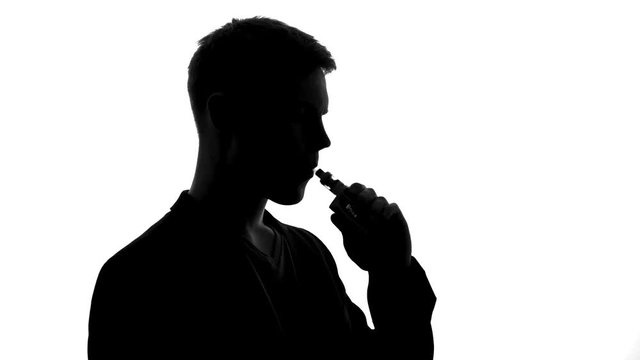 Male shadow smoking electronic cigarette, modern device creating tobacco feeling