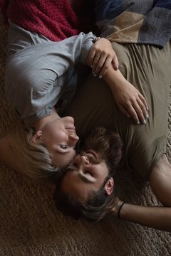 Couple relaxing on floor rug