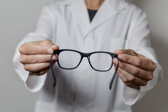 optician man bringing a pair of eyeglasses