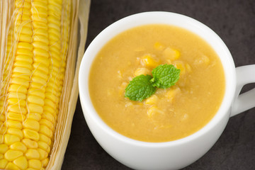 Corn soup in bowl and sweet corn on plate