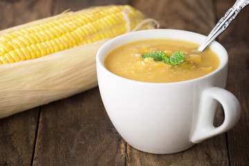 Corn soup in bowl and sweet corn on plate

