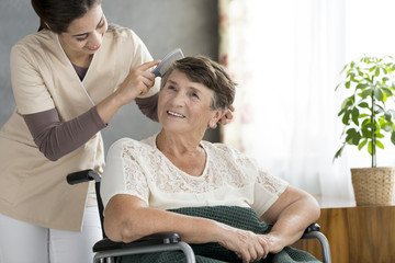 Volunteer combing odler patient's hair