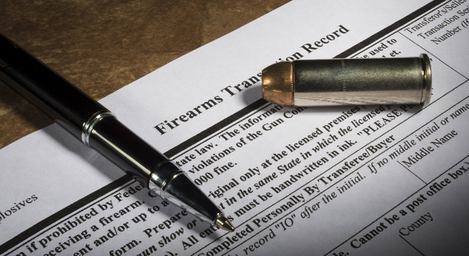FBI gun background check form 4473 with pen and bullet
