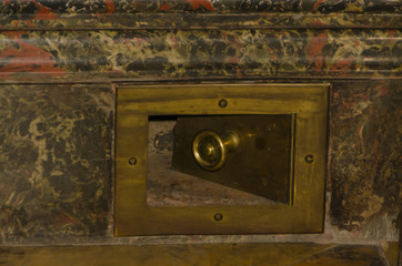 a granite wall antique brass air duct door