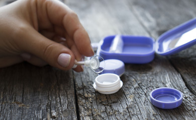 women's hands take out contact lenses from the container for contact lenses