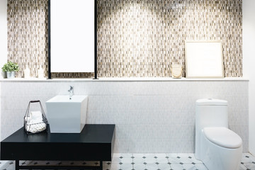 Modern spacious bathroom with bright tiles with toilet and sink. Side view