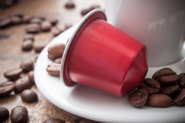 dosette de café expresso avec grains de café sur table en bois 