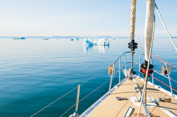Yacht sailing among icebergs in Greenland